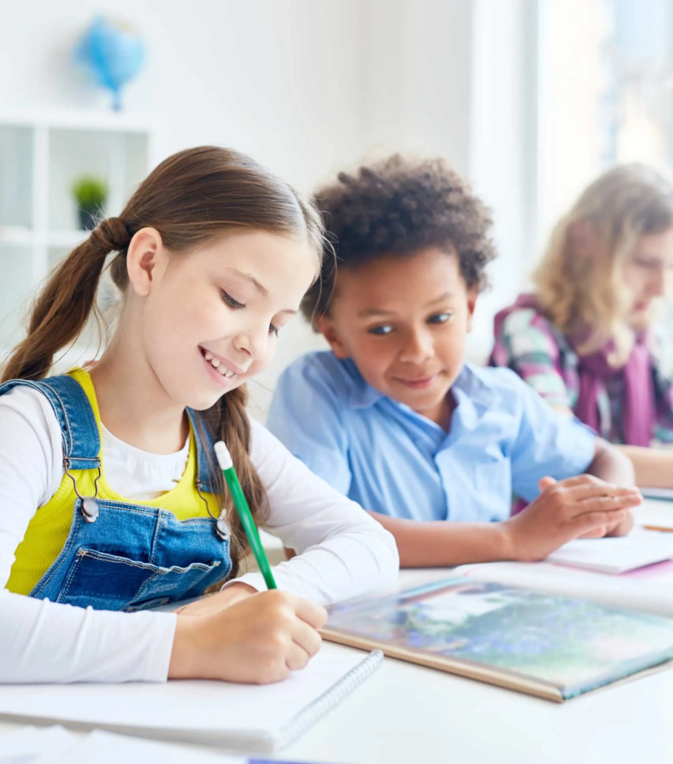 Un garcon regarde la copie de sa camarade de classe